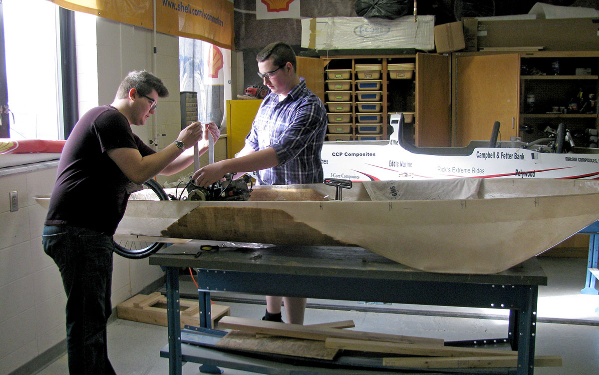 Cameron Gruntman, left, and Wesley Priem, right, work on one of the Super Mileage cars that they hope will reach 1,000 miles per gallon at the Shell Eco-Marathon in Houston, Texas, this April.
