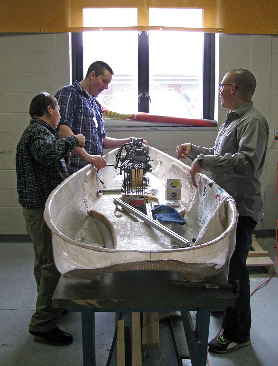 Teacher J.J. Johnson talks with Derick Schmucker and Wesley Priem about the Super Mileage car they hope will reach 1,000 miles per gallon at the Shell Eco-Marathon in Houston, Texas this April.